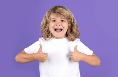 Excited kid boy with thumbs up on studio isolated background. Surprised face, amazed emotions of child