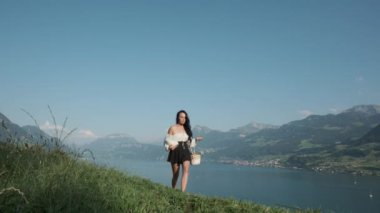 Köylü kız çayırda yürüyor. Seksi kız çim tarlasında yürüyor. Taşralı kadın süt şişesini açık havada tutuyor. Şehvetli kadınlar yaz yeşilliklerinde açık havada yürürler. Köydeki çiftçi kız.
