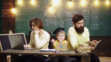 Ebeveynler çocuklara öğretiyor. Erken gelişim kavramında aile. Baba ve anne sevgili oğluna resim yapmayı öğretiyor.