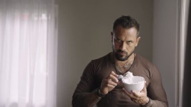 Ciddi siyahi bir adamın tıraş köpüğüyle sakal tıraşı olması. Tıraş fırçasıyla insan portresi. Yüzüne tıraş kremi süren yakışıklı bir genç. Adam yüz kremi sürüyor.