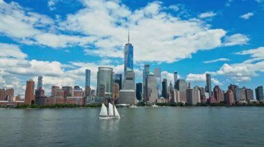 New York 'taki Manhattan ve One World Trade Center Weehawken New Jersey' den görüldüğü gibi. Manhattan 'ın gökdelenleri New York körfezinin dalgalanan sularının yanında mavi gökyüzüne karşı. NYC, ABD