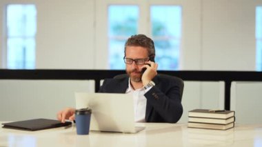 İş konuşmaları. Ofiste iş adamı telefonda konuşuyor. Akıllı telefon kullanan bir iş adamı. Ofisinde cep telefonu olan bir iş adamı. Yönetici ofis çalışanı telefonda konuşuyor.