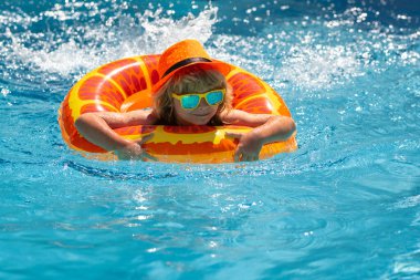 Çocuklar yüzme havuzu. Yaz tatili kavramı. Yaz çocukları sahilde deniz suyunda portre yapar. Mavi havuz kenarında