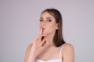Say secret hush be quiet with finger on lips. Shhh gesture isolated on studio background portrait. Girl showing hush. Woman say secret hush be quiet with finger on lips, shhh gesture