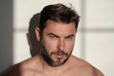 Kırklı yaşlarda yarı çıplak bir adamın portresi. Taze, pürüzsüz bir cildi olan, orta yaşlı, yakışıklı bir adam. Mükemmel yüzlü güzel bir adamın portresi. Yüz bakımı, erkek makyaj malzemeleri.