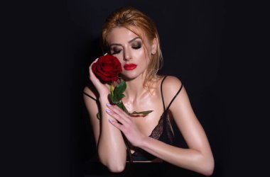 Kırmızı dudaklı, güzel bir kadın ve stüdyoda poz veren güllerle makyaj yapan bir kadın. Güzellik ve moda portresi