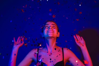 Konfeti üfleyen seksi kız. Sevgililer gününde güzel bir genç bayanın portresi. Seksi kadın güzellik mankeni doğum gününde ışıldıyor. Doğum gününü kutlayan şehvetli kadın. İyi ki doğdun