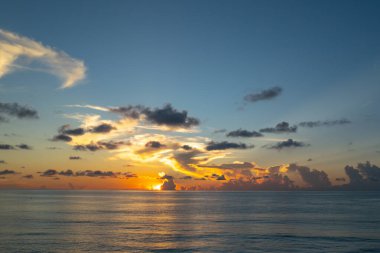 Gün batımı denizi. Bulutların arasından gün batımını izleyen sakin bir deniz. Meditasyon okyanusu ve gökyüzü arka planı. Huzurlu deniz manzarası. Günbatımı deniz suyunun üzerinde bir ufuk. Gün batımı gökyüzü sakin