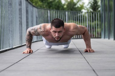 Muscular man lifting weights at gym. Handsome guy prepare to do exercises with dumbbell