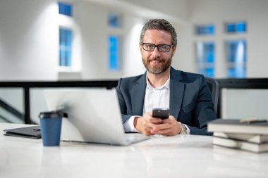 İş adamı iş yerinde telefonla konuşuyor. Modern ofiste çalışan uzaktan kumandalı bir çalışan. İş adamı hatta toplantı yapıyor. Ofiste bilgisayar kullanan bir iş adamı. Modern ofis işyeri