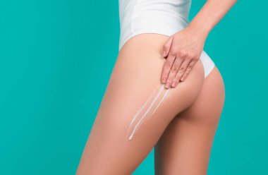 Cosmetic cream on woman buttocks with clean soft skin. Applying moisturizer cream on butt. Cellulite or anti cellulite treatment. Body care and spa salon concept