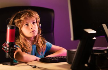 Küçük çocuk oyuncular masaüstünde bilgisayar oyunu oynarlar. Oyun akışı ve çocuklar için blog yazma. Güzel bir çocuk evde bir masaüstü bilgisayarı kullanarak bir ders öğrenir. Evde eğitim