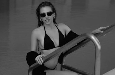 Mayolu seksi kadın havuzda dinleniyor. Suyun içinde bikinili seksi kız portresi. Yüzme havuzunda rahat bir kız. Havuz başında seksi bir manken. Hayatın tadını çıkar, yaz tatilleri, güneşlenme ve seyahatler.