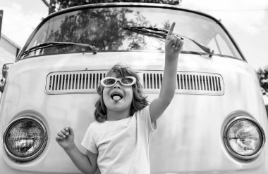 Pembe retro arabadaki mutlu çocuk. Hippi çocuk. Mutlu çocuk pembe bir minivanla seyahat ederken eğleniyor.