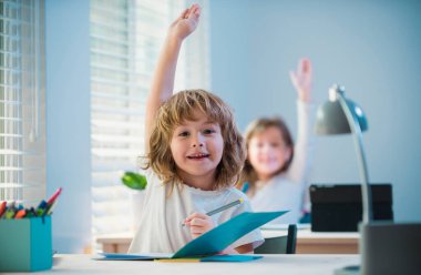 Okul çocuğu cevap veriyor. Sınıfta ders. Eğitim ve öğrenim. Erkek öğrenci ve kız öğrenci.