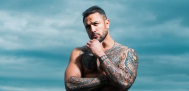 Vahşi, öfkeli bir çete üyesi yaşam tarzı, ciddi yakışıklı bir adam. Dramatik gökyüzünde açık hava erkek portresi