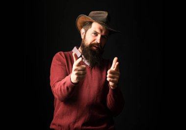 Kovboy parmakla işaret ediyor. Şerif ya da şerif. Kovboyla vahşi batı. Siyah üzerine tabanca taşıyan ciddi bir adam.