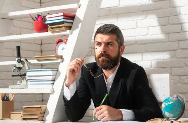 Sınıfta kendine güvenen beyaz erkek öğretmenin portresi. Erkek öğretmen ya da genç profesör. Masadaki öğretmen. Okuma, öğrenme, eğitim konsepti