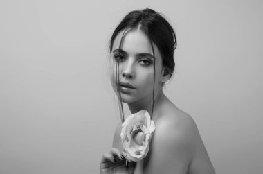 Sıska, seksi, çıplak omuzlu, kırmızı güller tutan, stüdyo arka planında soyutlanmış bir kadın. Çiçekli şehvetli bir kızın portresi