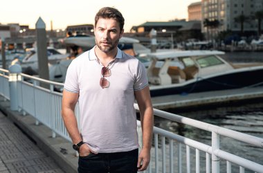 Günlük kıyafetleriyle Tampa 'da gezen şehir tarzı bir adam. Amerikan şehrinde günlük kıyafetleri olan çekici bir adamın portresi. Şehir modasında yakışıklı bir genç adam sokakta yürüyor.