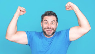 Şaşırmış ifadeli duygusal heyecanlı bir adam. İnsan tepkisi ve duyguları. Yüz ifadesi olan heyecanlı bir adamın stüdyo portresini kapat. Duygusal adam yumruklarını kaldırıyor, başarıyı kutluyor.