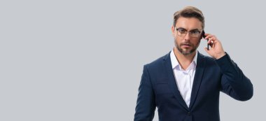 Takım elbiseli adam stüdyo arka planında izole edilmiş cep telefonu kullanıyor. Cep telefonu kullanan orta yaşlı bir adamın portresi. Akıllı telefonu olan adam stüdyo geçmişini izole etmiş. Banner, boşluğu kopyala