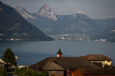 Alplerdeki kilise. İsviçre 'de Lucerne Gölü' nün yanındaki kilise. İsviçre köyündeki Alp dağlarındaki kilise. Alplerin kırsal kesimindeki dağların yakınındaki göl kenarındaki kırsal kilise. Dağ köyü