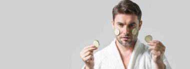 Banner of beauty man hold cucumber. Middle aged man with cucumber isolated on studio background. Cucumber for cosmetics skin mask. Facial mask with cucumber. Spa, dermatology and wellness clipart