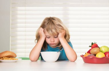 İştahsız bir çocuğun portresi. İştah kaybı kavramı. Çocuk robot yemek yiyor. Çocuklar için sağlıklı beslenme. Çocuk kahvaltıda ya da akşam yemeğinde iştahla yemek yer.