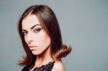 Kadın güzelliğinin visage kavramı. Genç kız Studio gri arka plan üzerinde. Yakın çekim portre. Saç şekillendirme