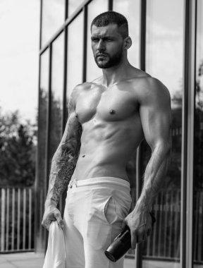 Spor salonunda poz veren kaslı iri kıyım. Spor aletlerinin yanında fitness mankeni. Genç kaslı adam egzersizi. Spor salonundaki güçlü kaslı adam. Spor ve motivasyon. Ağırlıkla egzersiz yapar