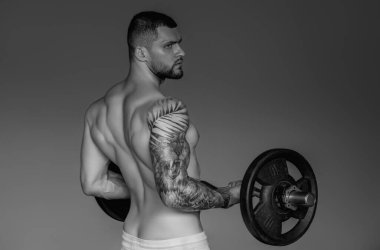 Handsome man preparing for workout. Sport. Weight workout. Guy doing bodybuilding workout in gym. Sport, bodybuilding and fitness. Man exercising with dumbbell. Hard workout