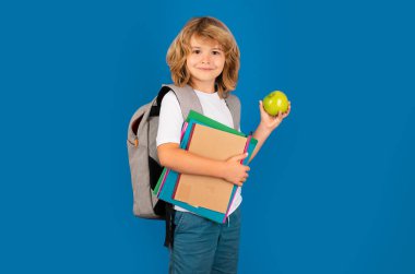 Okul üniformalı, sırt çantalı bir çocuk. Tecrit edilmiş genç bir öğrenci. Gülümseyen mutlu okul çocuğunun portresi. Pozitif duygular