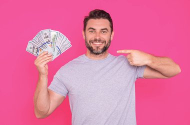 Çekici bir iş adamı para sayıyor. 100 dolarlık banknotlar tutan yakışıklı orta yaşlı bir adam. Parası olan başarılı bir iş adamı. Kâr ve finansal başarı. Dolar nakiti olan zengin bir adam.