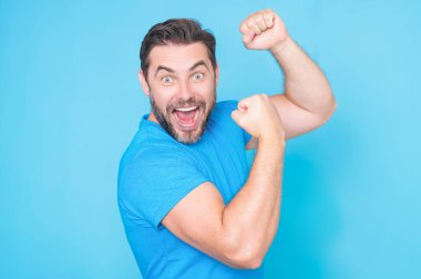 Heyecanlı adamın duygusallığı. İnsan tepkisi ve duyguları. Yüz ifadesi olan heyecanlı adama yaklaş. Mutlu ve heyecanlı adam, kazanan jest yapıyor. Kolları havada, gülümsüyor ve başarı için bağırıyor.