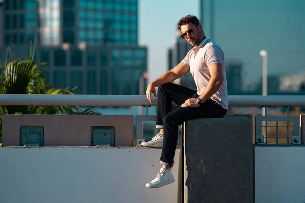 stock image Stylish man wearing sunglasses and shirt. Handsome man outdoors portrait. Portrait of stylish male model outdoor. Fashion male posing near skyscraper on the street. Fashionable man in urban style