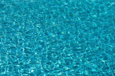 Mavi havuz suyu arka planı. Bulanık şeffaf, durgun su yüzeyi dokusu. Güneş ışığı altında su dalgaları kopyalama alanı ile