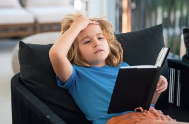 Hayali çocuk. Odadaki kanepede uzanmış kitap okuyan sıradan giyinmiş tatlı bir çocuk.