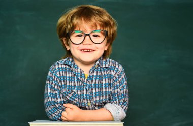 Çocuk tahtanın arka planında sınıfta öğreniyor. Evde öğrenmek. Mutlu okul çocukları. Eğitim süreci. Okula geri dön ve mutlu zamanları