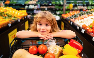 Süpermarketten alışveriş yapan çocukların yakın portresi. Alışveriş arabası, market konsepti.