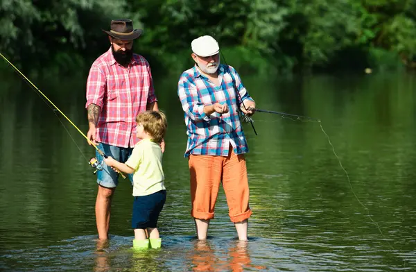 stock image Anglers. Fly fishing for trout. Father teaching son how to fly-fish in river. Grandfather and father with cute child boy are fishing