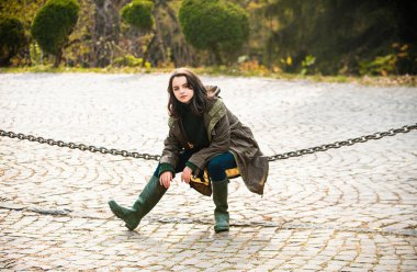 Genç bir delikanlı sonbahar parkında yürüyor. Ergenlik modası. Şehir parkında modern elbiseler giyen şık hippi kız.