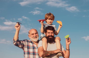 Boş zaman aktivitesi. Büyükbaba oyun zamanı. Mutlu gülümseyen çocuk, baba kameraya bakıyor. Jenerasyon konsepti. Erkek çoklu nesil portresi