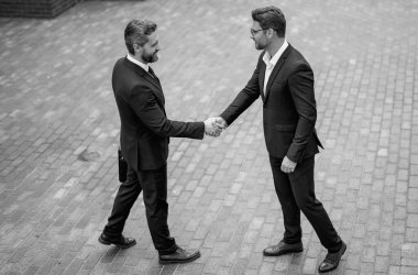 Amerikalı iş adamı partneriyle tokalaşıyor, başarılı bir takım çalışması. İki iş adamı sokakta el sıkışıyor. Takım elbiseli işadamları dışarıda el sıkışıyor. İki iş adamı arasında tokalaşma