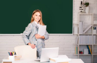 Lisede ya da üniversitede ders hakkında kitap tutan kız öğrenci