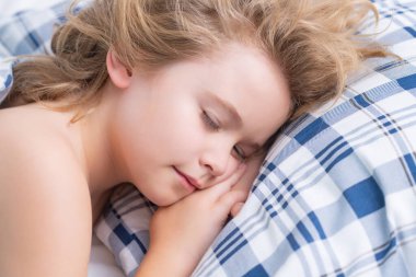 Günlük uyku. Çocuk evde yatakta uyuyor. Yatma zamanı, çocuklar uyuyor. Çocuk yastıkta uyuyor, sağlıklı bir uyku çekiyor.