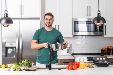 Aşçı mutfakta çorba pişiriyor. Aşçı çorba kasesini çorba tenceresiyle hazırlar. Çorba tarifi. Şef modern mutfakta çorba pişiriyor. Olgun aşçı mutfakta yemek hazırlıyor.