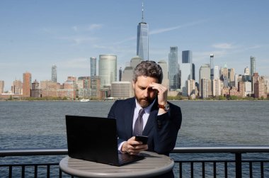 New York 'ta dışarıda dizüstü bilgisayar kullanan bir iş adamı. İş dünyası Amerikan başarısı. Amerikan iş rüyası. Manhattan yakınlarında takım elbiseli Amerikalı iş adamları. ABD 'de online iş