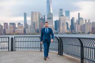 Takım elbiseli bir iş adamı, NYC 'deki Urban Caddesi' nde dizüstü bilgisayar tutuyor. Açık havada başarılı bir iş adamı. Ofisin dışında dizüstü bilgisayar kullanan orta yaşlı bir iş adamı. Olgun iş adamının sokak portresi.