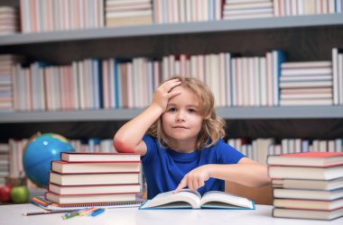 Bilgi ve eğitim okulu konsepti. Öğrenci kütüphanede kitap okuyor. Çocuklar okumayı öğrenir. Kitapçıda kitap okuyan bir çocuk